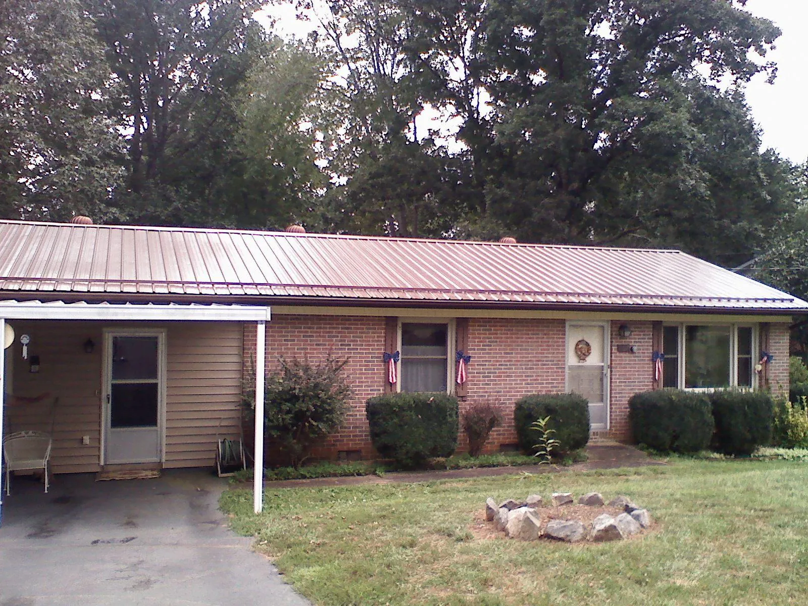 Bronze metal roof and carport on a brick ranch home — Roof Repair work by our crew in Thatcher